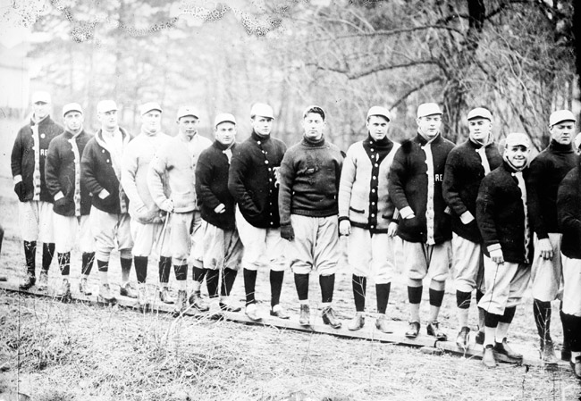 Group of white men in sports uniforms standing in line