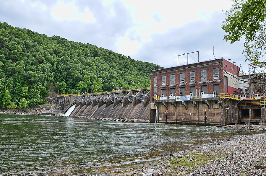 Close-up of concrete dam with turbine room on river