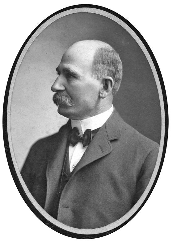 Profile view of white man with mustache in suit and bow tie in oval frame