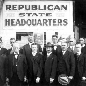 Group of white men in suits posing in front of building with "Republican State Headquarters" written on it