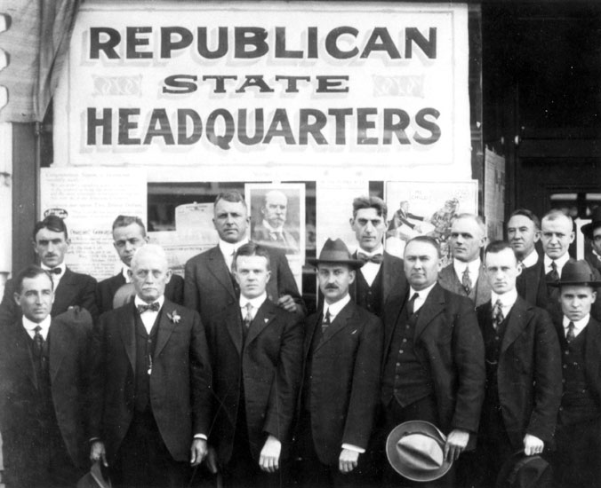Group of white men in suits posing in front of building with "Republican State Headquarters" written on it
