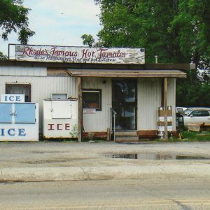 Country restaurant by road with corrugated walls with sign and ice coolers