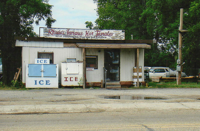 Country restaurant by road with corrugated walls with sign and ice coolers