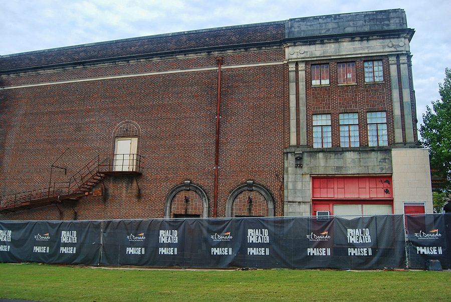 Side entrance on brick theater building with stairway and fence