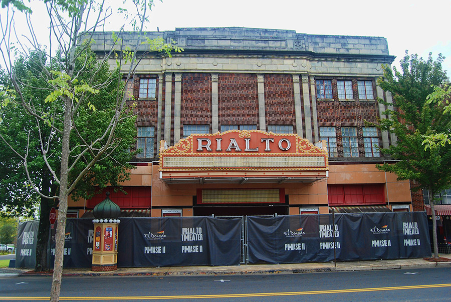 Three-story brick theater building with "Rialto" marquee and fence