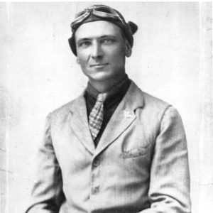 White man in suit with pilot's goggles on his head