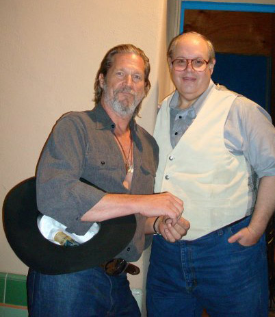 Two older white men smiling in shirts and jeans