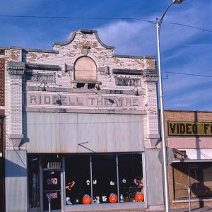 Multistory brick building with glass display windows and "Riddell Theater" written above the entrance