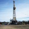 Natural gas derrick with flags and blue skies