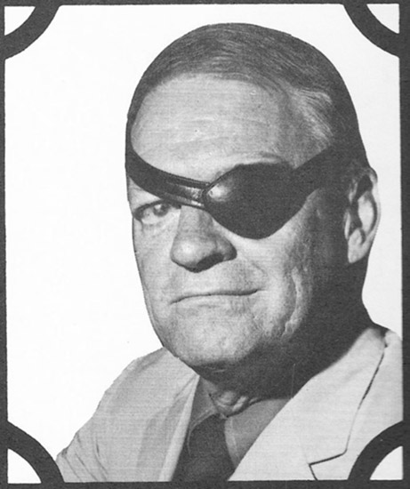 White man with black leather eye patch over left eye in suit and tie