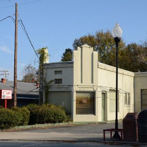 Abandoned gas station building with weathered sign and parking lot