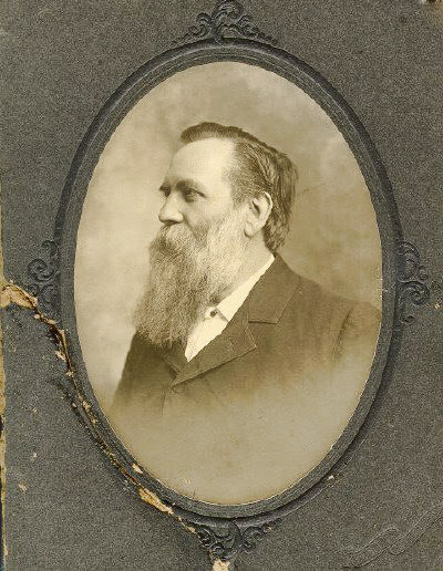 Profile view of white man with long beard in suit in oval frame