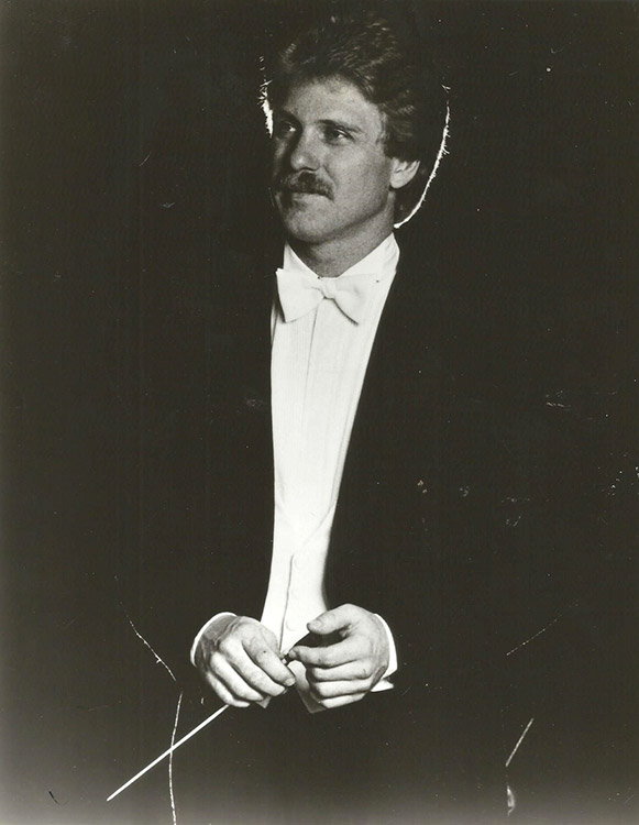 White man with mustache in suit and bow tie