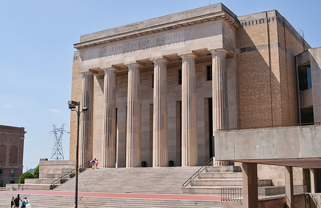 Large brick and concrete building with steps and six columns