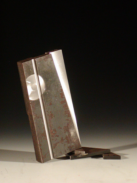 Flat stock steel sculpture with cut out sections then stacked propping original piece at angle