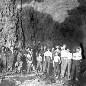 Mixed group of men with hats and overalls digging underground