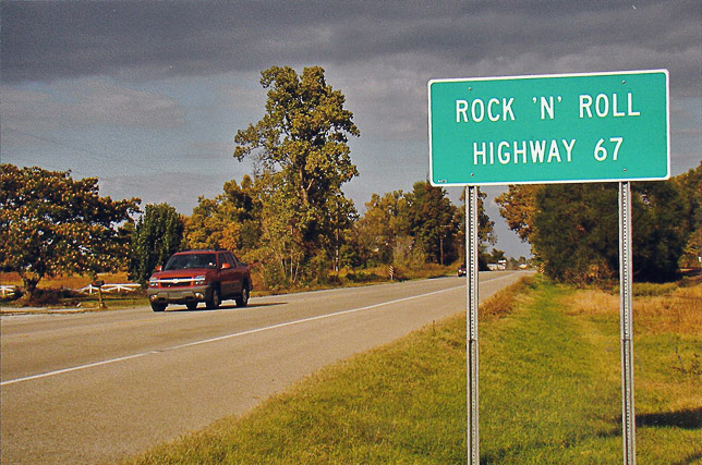 "Rock N Roll Highway 67" sign with street and red truck
