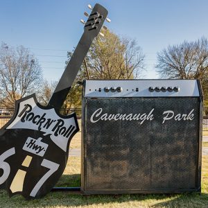 Giant guitar and amplifier shaped signs on grass