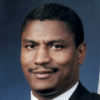Portrait black man suit and tie smiling short hair blank photo backdrop