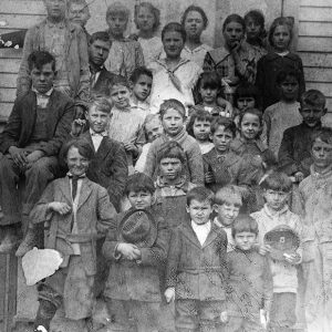Group of white children on steps of school house