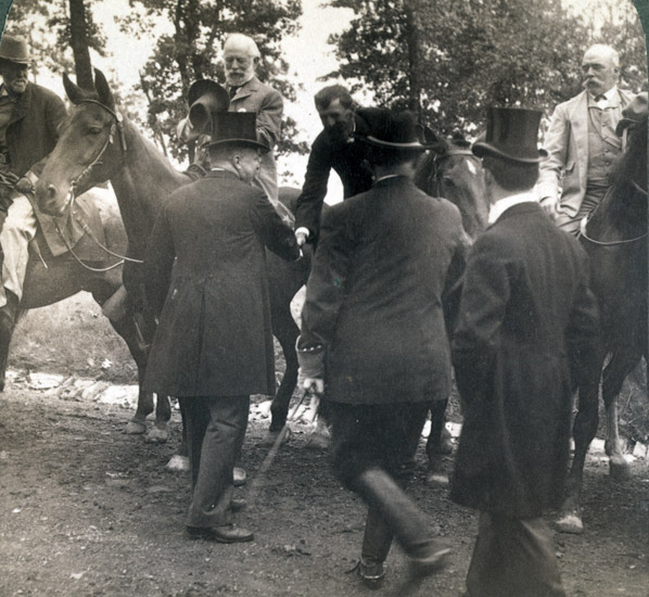 White men on horseback with white men in suits on foot