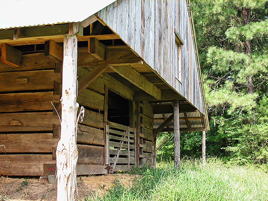 Close-up of wooden barn with metal roof and gate