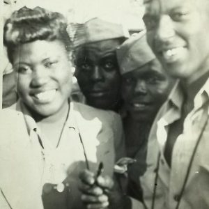 African-American men smiling in military uniforms with African-American woman smiling in suit