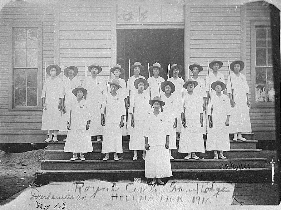 African-American women in matching dresses with hats on steps of building