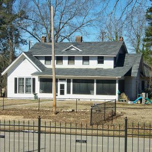 Two-story house with screened in porch and fence