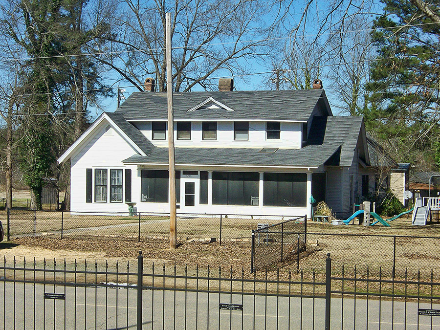Two-story house with screened in porch and fence