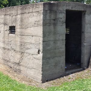 One room concrete jail building with tiny widows and open door