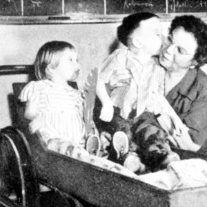 Older white woman sitting with two white children