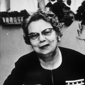 Older white woman with glasses sitting at desk