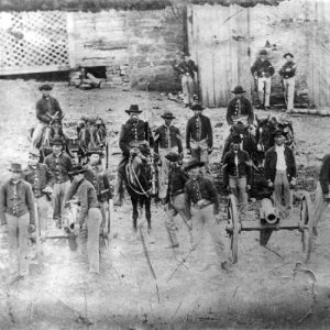 White men with horses and artillery cannon in military uniforms