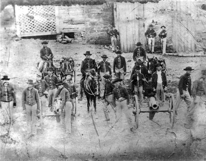 White men with horses and artillery cannon in military uniforms