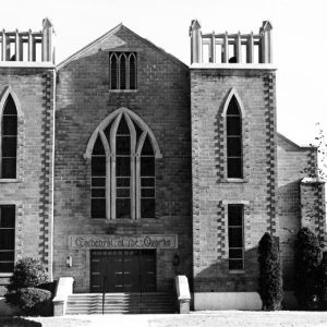 Brick church with towers and gothic style arched windows