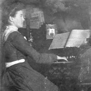 Young white woman in a dress playing an organ