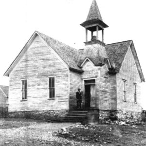Wooden building with steeple and man in a suit