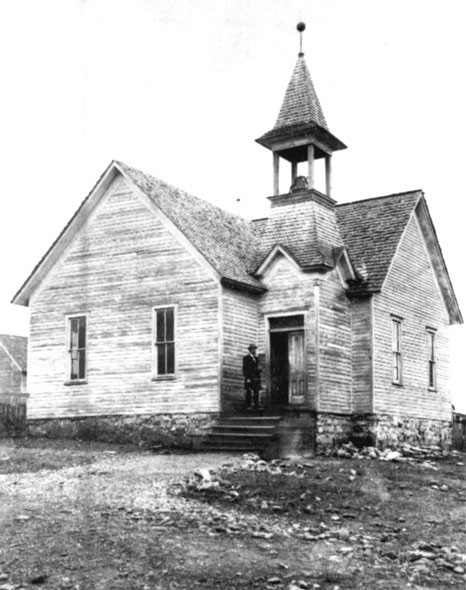 Wooden building with steeple and man in a suit