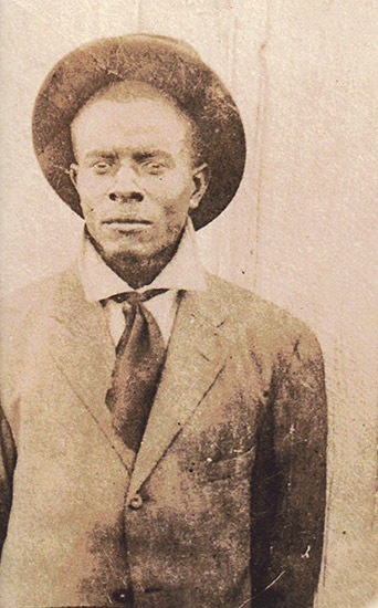 old faded photo of African-American man in hat and suit and tie
