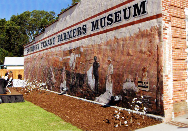 Cotton farmers painted on exterior mural of brick building with banner text "Southern Tenant Farmers Museum"