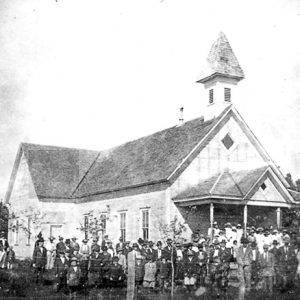 Church building with cupola and white congregation