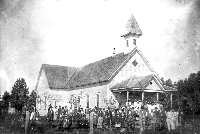 Church building with cupola and white congregation