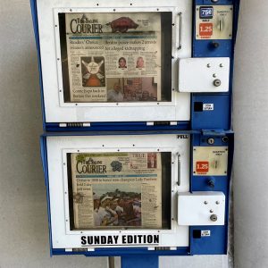 Newspaper dispensing box featuring two different issues of the Saline Courier