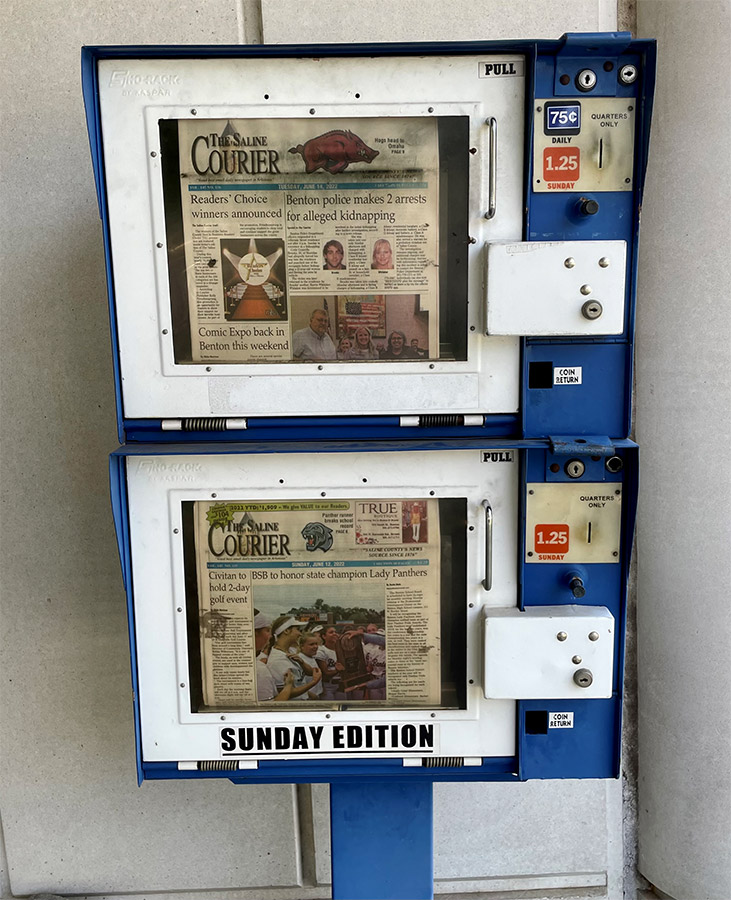 Newspaper dispensing box featuring two different issues of the Saline Courier