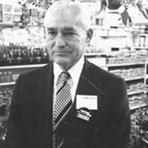 Old white man in suit and tie standing in store
