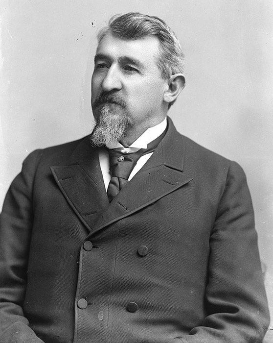 White man with beard in suit and tie