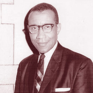 African-American man with glasses smiling in suit and tie