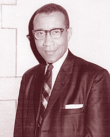 African-American man with glasses smiling in suit and tie