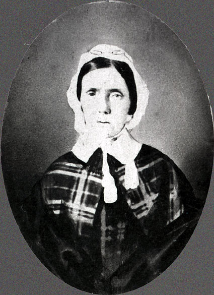 Older white woman wearing a bonnet and dress with collar